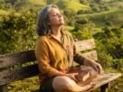 Mulher brasileira respirando com paz na natureza, vencendo a ansiedade pela fé e confiança em Deus