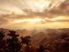 Amanhecer dramático sobre o horizonte com raios dourados, simbolizando o tempo de Deus no significado de Kairós