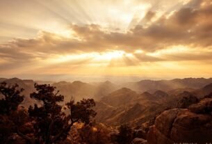 Amanhecer dramático sobre o horizonte com raios dourados, simbolizando o tempo de Deus no significado de Kairós