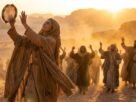 Mulher dançando com alegria no deserto com mãos levantadas, representando a profetisa Miriã louvando a Deus